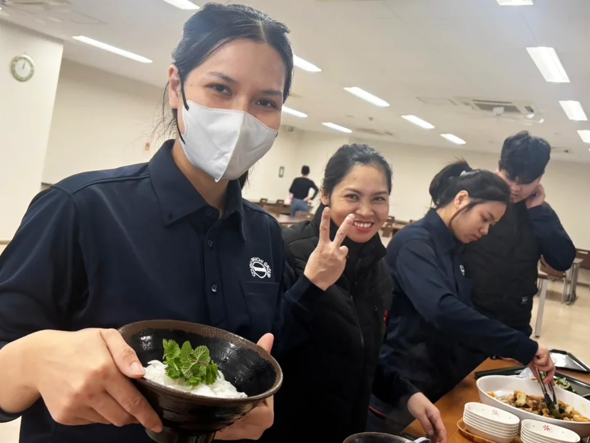 中部第一輸送の社員食堂でスタッフたちがご飯をよそって笑顔を見せる様子
