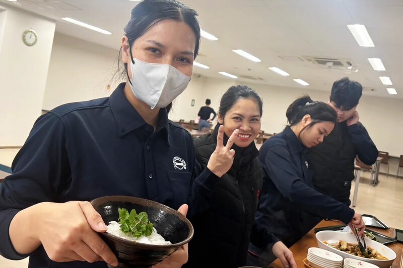 中部第一輸送のスタッフたちが仲良く食事をよそっている様子