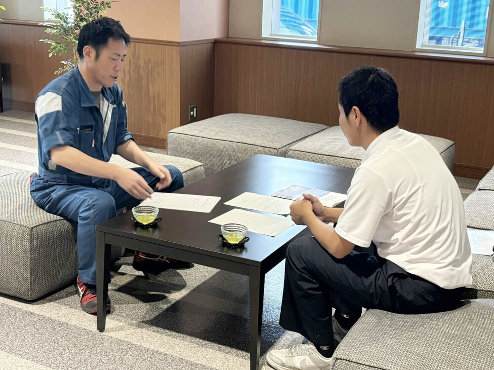 応接室で業務説明を受ける高校生