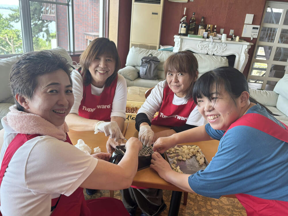 女性社員が楽しそうににんにくの下ごしらえをしている様子