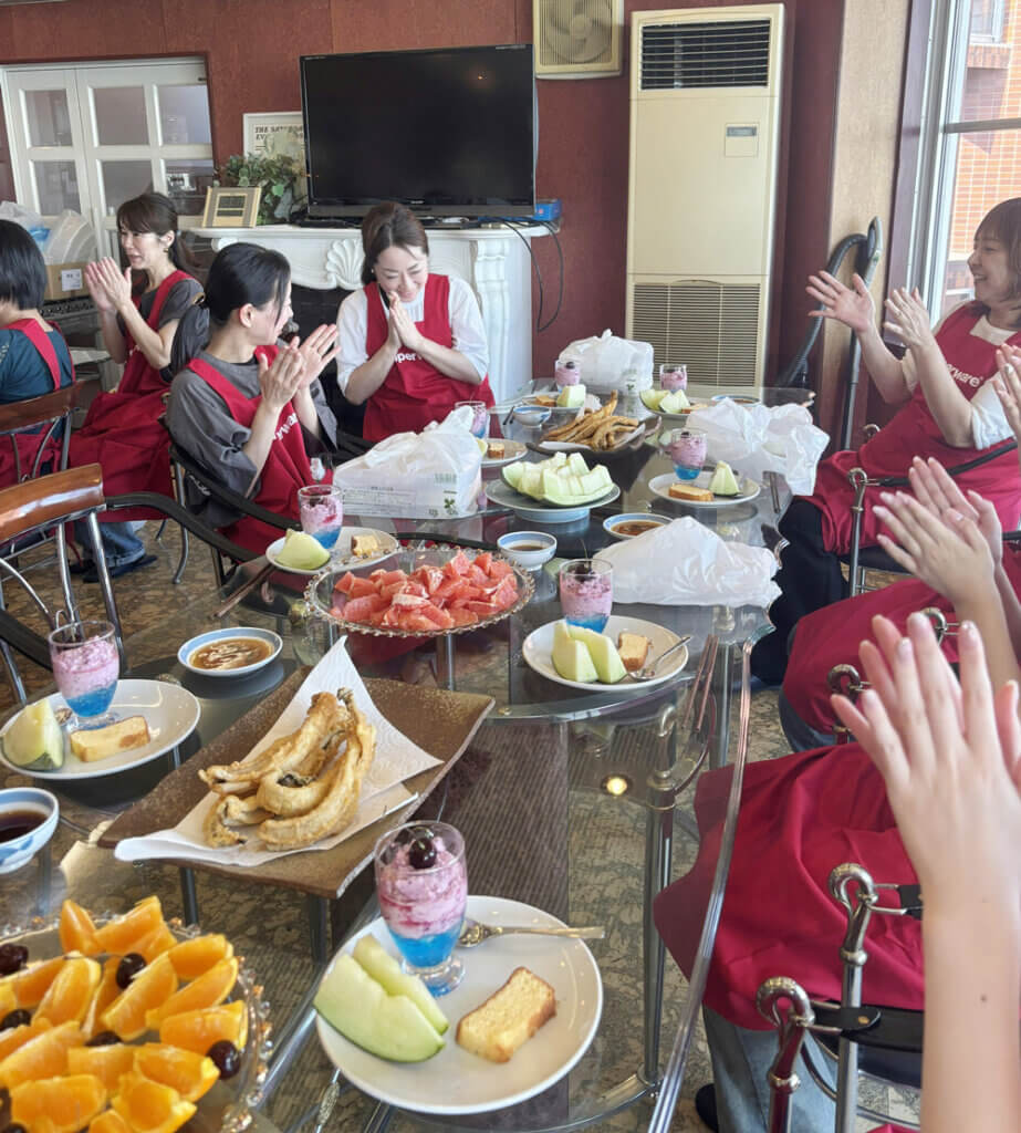 料理を囲んで笑顔で食事を楽しむ女性社員たち