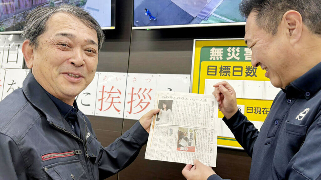 `新聞紙の上で重ねられた、母と娘の二つの手。家族の絆を象徴する心温まる写真。`
