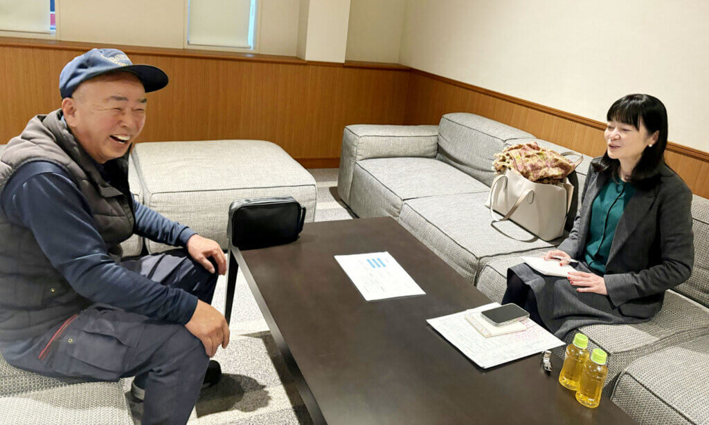 小日向るり子先生と中部第一輸送の社員が個人面談を行っている様子。和やかな雰囲気の中、社員が日々の業務について相談している