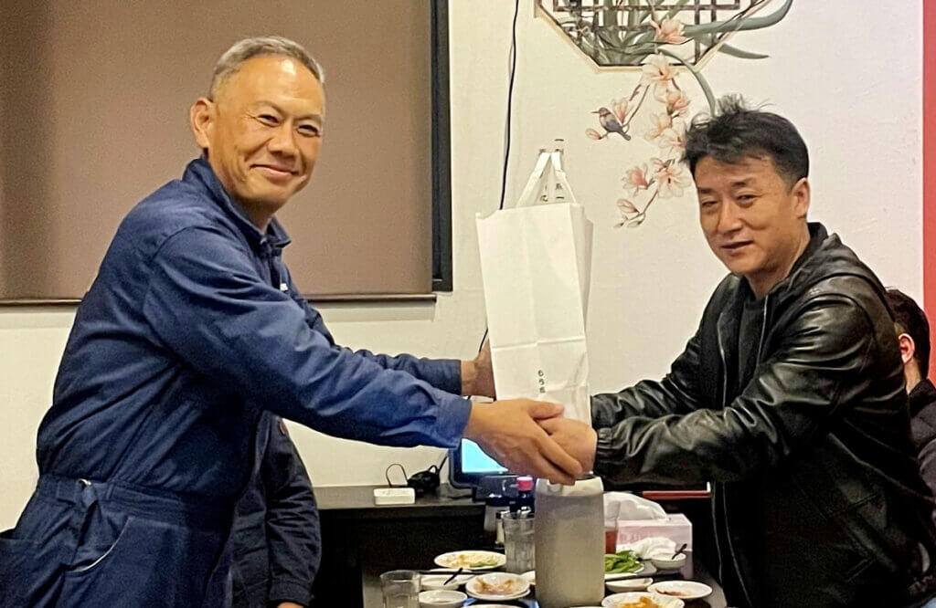 中部第一輸送の技能実習生歓送迎会で握手を交わす社長とファン・ユーシーさん。送別と歓迎の温かい瞬間