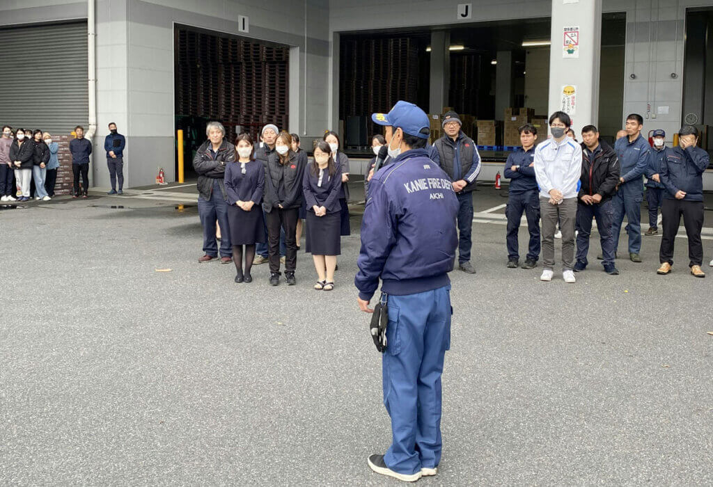 ```
中部第一グループの消防訓練で、海部南部消防組合の消防署員から説明を受ける全社員