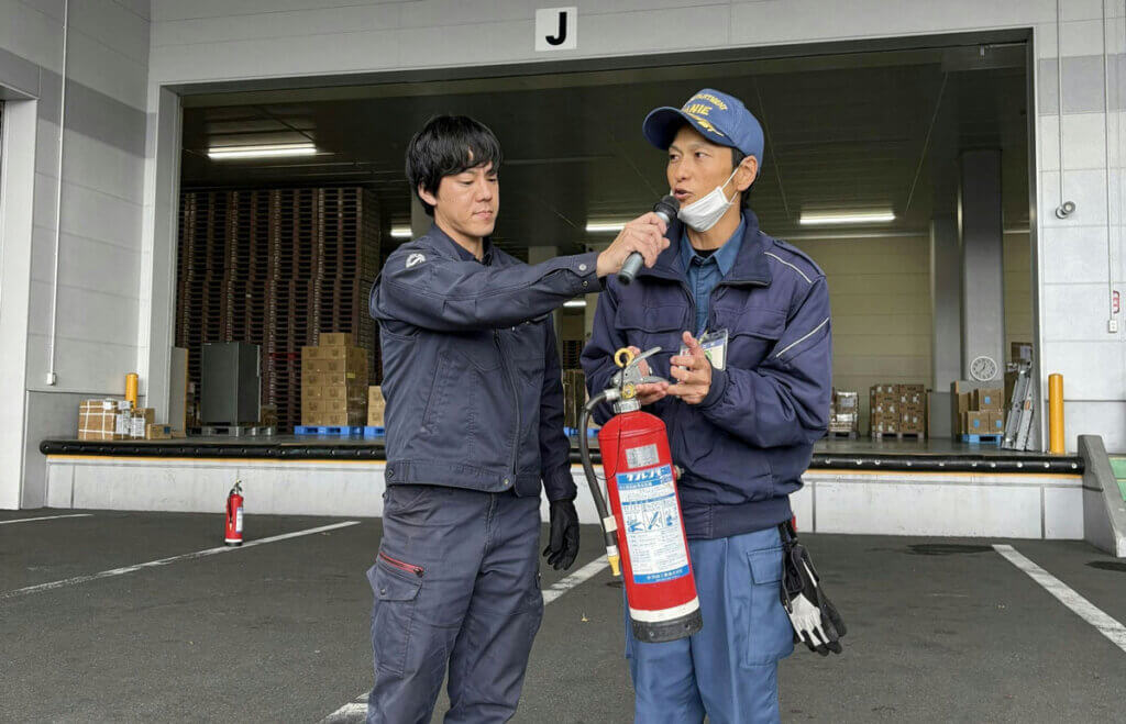 消防署員から消火器の正しい使い方を学ぶ中部第一グループの社員。実践的な防災訓練の様子