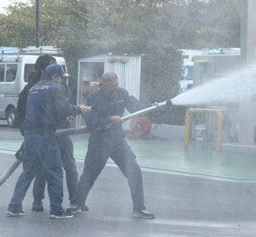 消防署員による放水訓練の実演。本格的な消防訓練に真剣に取り組む中部第一グループ