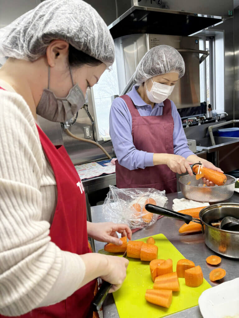小平先生の指導のもと、スタッフが人参を大きめにカットしている調理風景