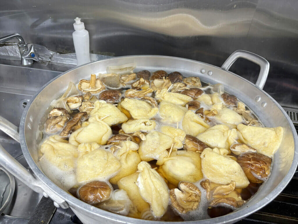 社員食堂で仕込み中のおでん。信田袋と干し椎茸がコトコトと煮込まれている様子