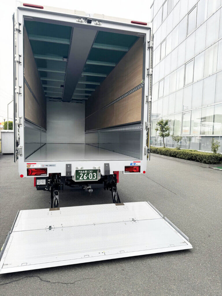 10トンパワーゲートウイング車の昇降板が地面まで展開した状態。荷台内部も確認できる。
